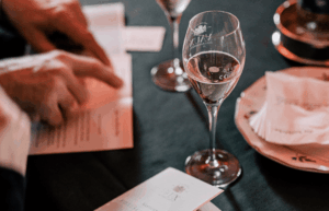 Eine Menükarte und ein Glas Sekt auf einem Tisch