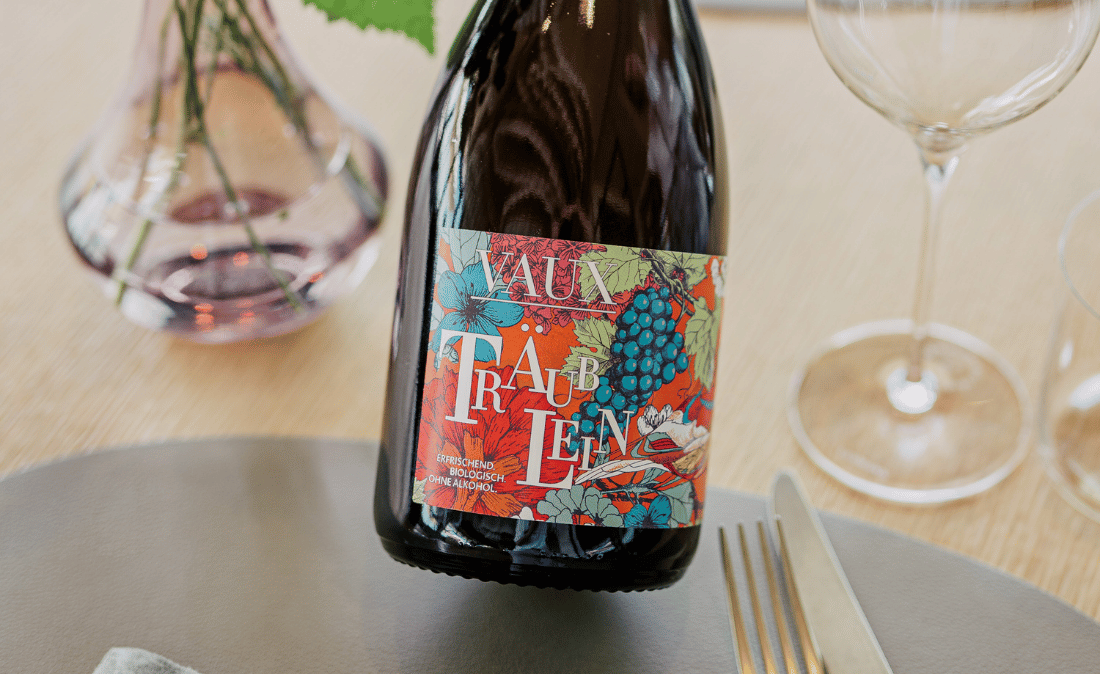 Eine Flasche Träublein auf einem gedeckten Tisch