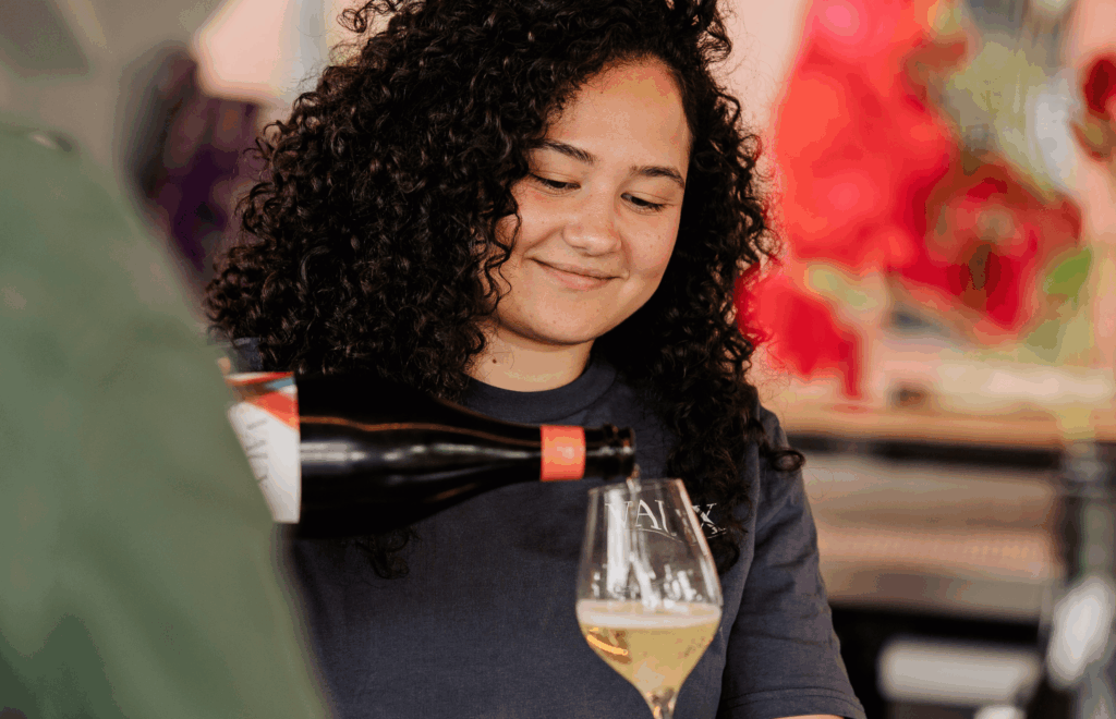 Eine Frau die ein Glas Sekt einschenkt