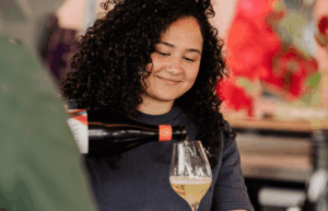 Eine Frau die ein Glas Sekt einschenkt