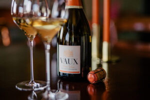 Eine geöffnete Flasche Cuvee VAUX und zwei Gläser