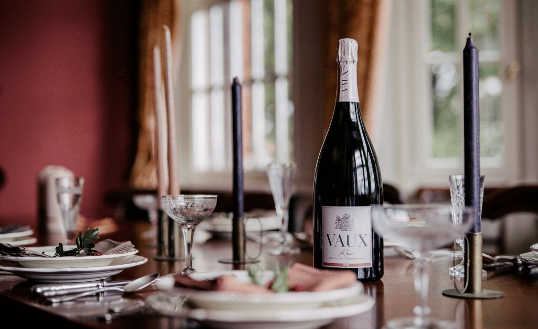 Ein festlich gedeckter Tisch mit einer Flasche Magnum Rose